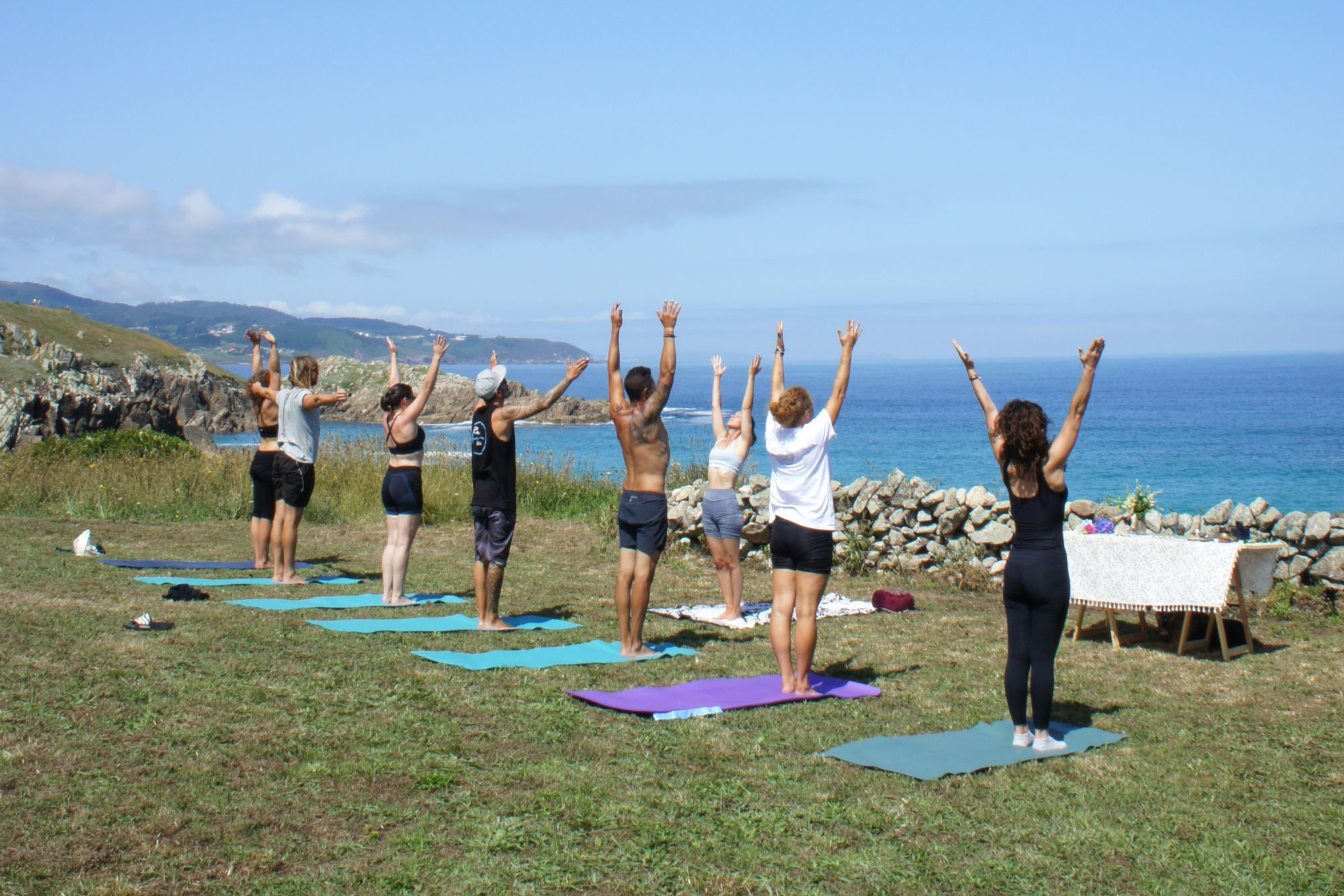 Grupo practicando yoga al aire libre durante una experiencia compartida